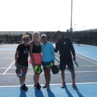 Four Lakers standing together on the Pickleball courts.